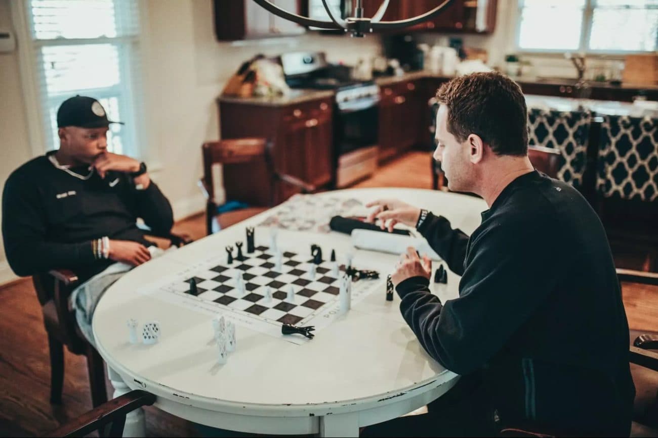 Seth Makowsky playing chess with Josh Dobbs in a kitchen.
