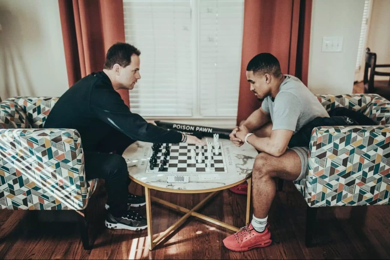 Seth Makowsky playing chess with Jalen Hurts at a table.